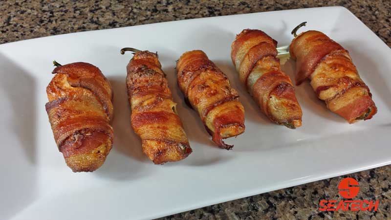 bacon wrapped crab stuffed jalapeno poppers A photograph of bacon wrapped, Chilean crab meat stuffed jalapeno poppers.