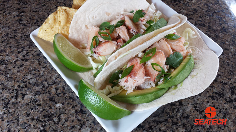 chilean crab tacos A phtograph of crab tocaos with crab meat, cabbage, sour cream, cilantro, green onions, avocaodo and sliced limes