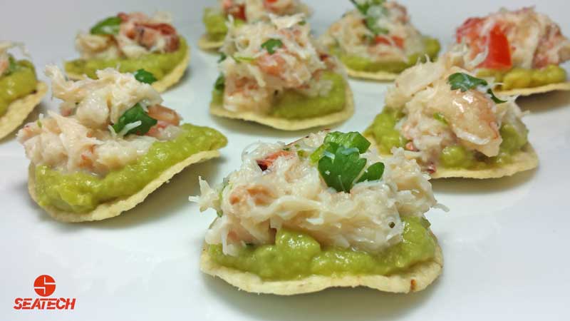 mini crab tostada appetizers A photograph of mini crab tostada appetizers with crab meat, avocado, cilantro, onion, mayonnaise and lime juice.